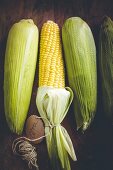 Four corncobs on a wooden background