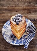 A waffle heart stack with blueberries and icing sugar