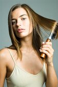 A dark blonde woman brushing her hair