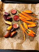 Vegan oven cooked vegetables (carrots, Jerusalem artichoke, Tonda di Chioggia) on baking paper