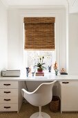 White desk and Tulip Chair below window with bamboo roller blind in retro interior