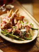 Grilled asparagus and breadsticks wrapped in Parma ham