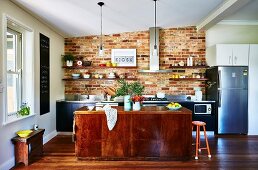 Kitchen with brick wall, kitchen island and wooden floor