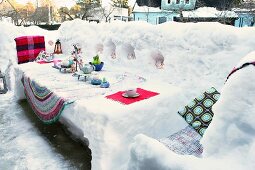 Schneebedeckter Terrassenplatz, mit dekoriertem Schnee-Tisch