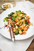 Tomato-infused barley risotto with tofu, peanuts, spinach and black caraway