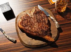 Gegrilltes T-Bone-Steak auf Holzteller mit Steakmesser
