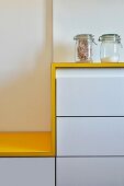 White kitchen counter with yellow worksurface continuing into seat