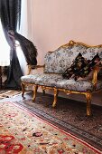 Baroque sofa on various rugs next to stuffed peacock
