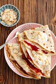 Pancakes with cherry jam, yoghurt and flaked almonds