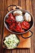 Gegrillte Hähnchenflügel und -keulen mit Baked Potatoes, Tzatziki und Kratusalat mit Gurken