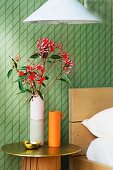 Red flowers on the bedside table made of gold plate and wooden trunk