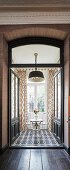 Silver bistro table and two chairs in front of French windows