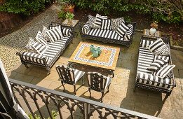 View down onto terrace with black and white striped cushions on outdoor furniture