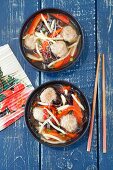 Oriental soup with meatballs, mu-err mushrooms, bamboo shoots, pepper and rice noodles