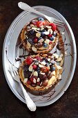 Shortcrust tartlets with vanilla cream, summer berries, flaked almonds and chocolate glaze