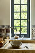 Traditional sink unit with vintage tap in front of lattice window