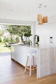 Designerküche mit Barhocker und Kücheninsel aus Naturstein