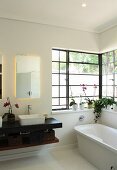 Badezimmer mit freistehender Badewanne und schwarzer Waschtischplatte