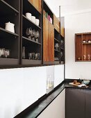 Crockery and glasses on elegant fitted shelves above serving hatch