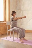 Holzhackerin (Yoga), Schritt 1: Sitzen, Arme nach vorne, Finger verschränken