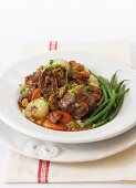 Oxtail stew with onions, carrots and mushrooms
