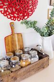 Wooden box with various storage jars and jug vase with leaf branch