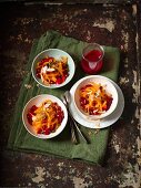 Persimmon salad with pomegranate seeds, coconut, pistachios and berry sauce