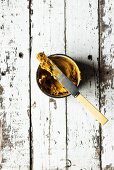 Masala garlic butter in a dish with a knife (seen from above)