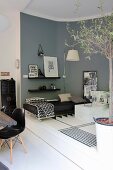 Couch and grey wall on raised platform next to classic chair and table