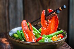 Noodles with vegetables, lobster and chopsticks (Asia)