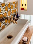 Vintage-style washstand with old-fashioned tape, ornate tiles and stained glass in niche to one side