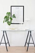 Houseplant, candlestick and Panton lamp on delicate console table made from trestles and glass panel