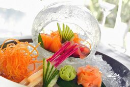 Sashimi on a serving platter and within a decorative ice cube (Japan)