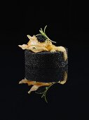 Black Food: Kaviar-Timbal mit frittiertem Teig, Schaum und Estragon auf schwarzem Untergrund mit Reflexion