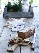 Rye spelt bread with walnuts and cranberries on a wooden board and a wooden table