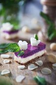 A slice of cheese cake with white chocolate, Macadamia nuts and blueberry cream