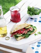 Ciabatta sandwich with steak strips, vegetables and beetroot tzatziki