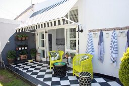 Yellow chairs and chequered floor on summer terrace