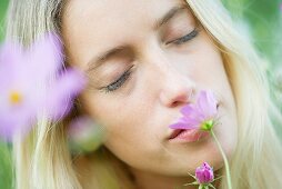 Young woman smelling flowers with eyes closed