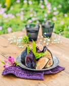 Violette Feigen auf Zinnteller am Gartentisch