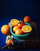 Oranges, whole and halved, in a basket and next to it