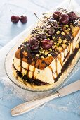 No-bake cake with cherries, pistachio nuts and chocolate sauce