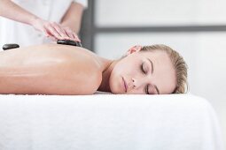 A woman having a hot stone massage in a spa