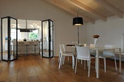 Dining table and view into kitchen through modern folding door