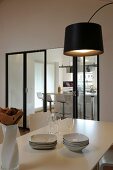 View across dining table and through modern folding doors into kitchen