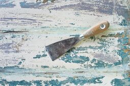 Spatula on wooden surface with peeling paint