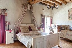 Romantisches Schlafzimmer mit Baldachin und Rosenmuster im Landhausstil