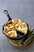 Potato frittata with feta cheese and sausage in a cast-iron pan