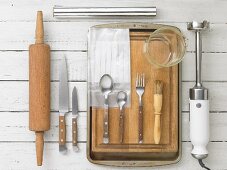 Kitchen utensils: a rolling pin, knives, cutlery, a pastry brush and a hand blender