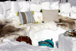 Winter picnic on bench carved from snow covered in furs